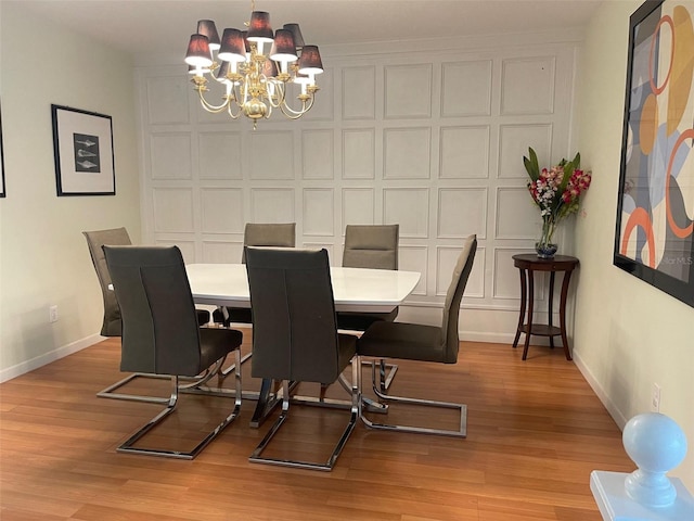 dining area with light hardwood / wood-style flooring and a chandelier