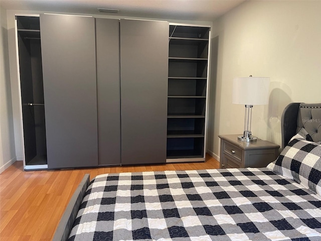 unfurnished bedroom with light wood-type flooring and a closet