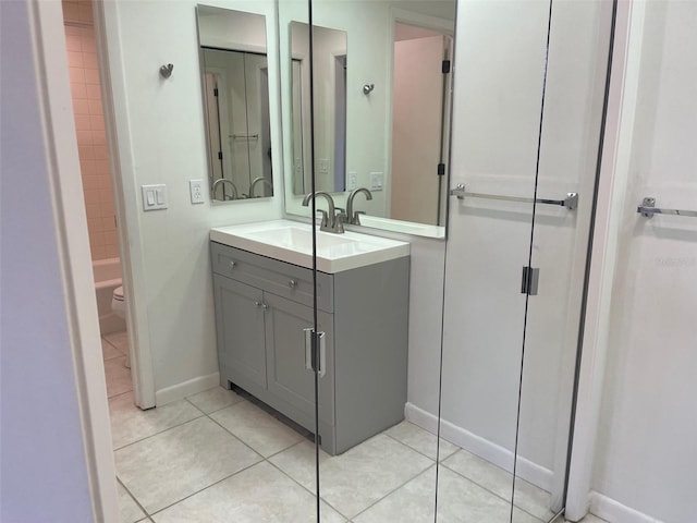 bathroom with tile patterned flooring, vanity, toilet, and walk in shower