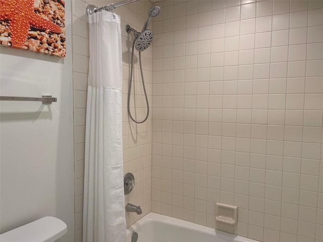 bathroom featuring shower / bath combo and toilet