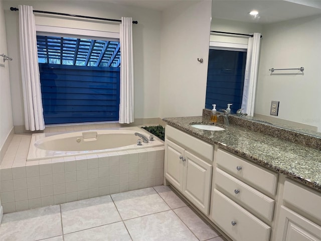 bathroom featuring tiled tub, tile patterned flooring, and vanity