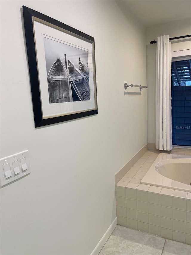 bathroom with tile patterned floors and tiled tub