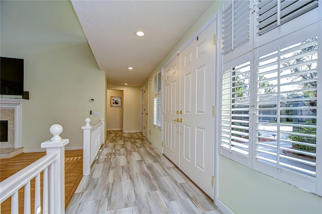 hall with light hardwood / wood-style floors and a wealth of natural light