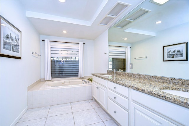 bathroom with tile patterned flooring, vanity, a healthy amount of sunlight, and tiled bath