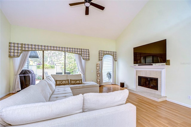 living room featuring a fireplace, hardwood / wood-style floors, vaulted ceiling, and ceiling fan