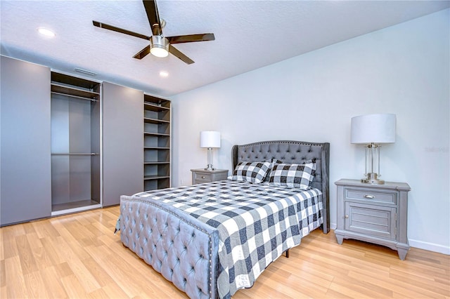 bedroom featuring ceiling fan, light hardwood / wood-style floors, and a textured ceiling