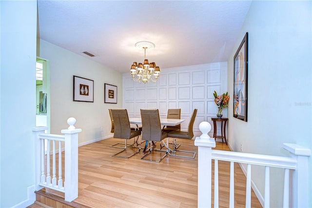 dining space featuring a notable chandelier and light hardwood / wood-style floors