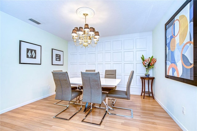 dining area featuring light hardwood / wood-style flooring and an inviting chandelier