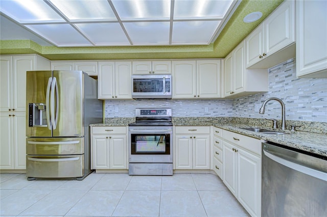 kitchen featuring white cabinets, light stone countertops, sink, and appliances with stainless steel finishes