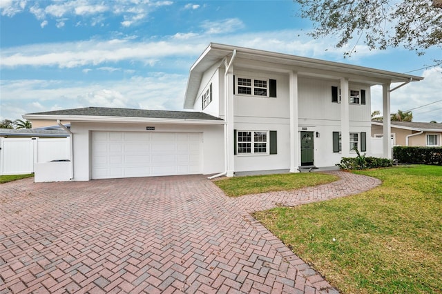 view of front of home with a garage and a front lawn