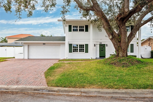 view of front of house featuring a garage and a front lawn