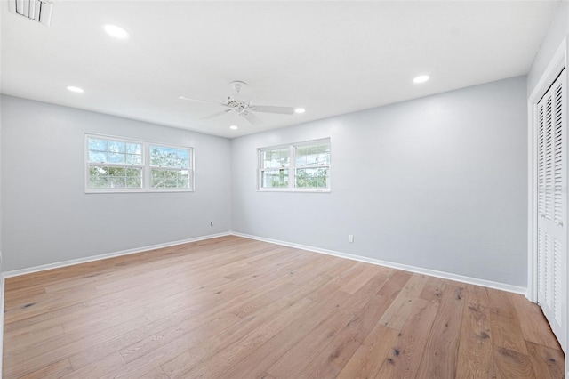 unfurnished bedroom with ceiling fan, light wood-type flooring, and a closet