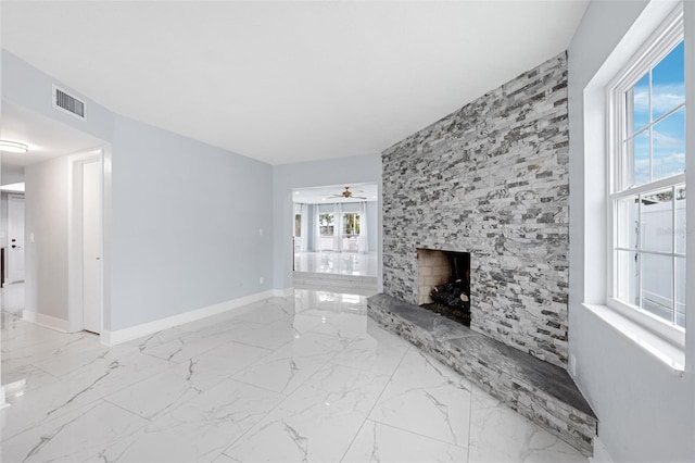 living room featuring a stone fireplace and ceiling fan