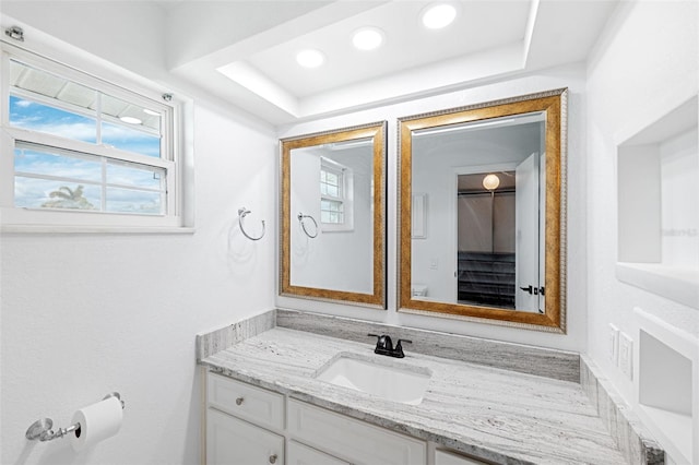 bathroom with a tray ceiling and vanity