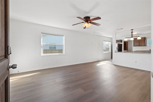 unfurnished living room with ceiling fan and dark wood-type flooring