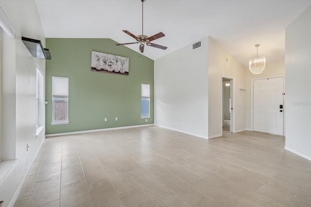 empty room featuring ceiling fan with notable chandelier and high vaulted ceiling