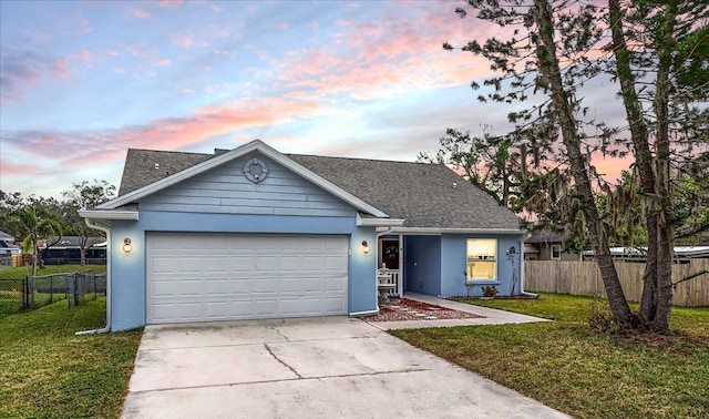 view of front of home featuring a garage and a yard