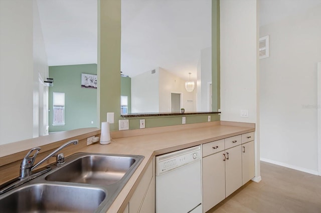 kitchen with dishwasher, kitchen peninsula, sink, vaulted ceiling, and white cabinetry