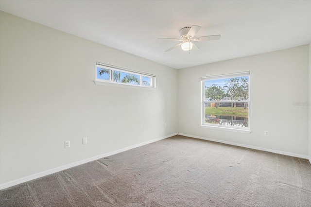 carpeted spare room with ceiling fan