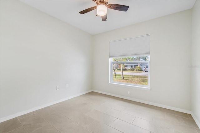 spare room with ceiling fan and light tile patterned floors