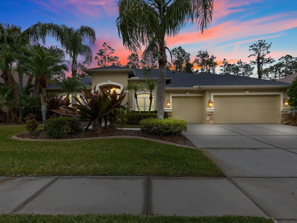 view of front of home featuring a garage and a lawn