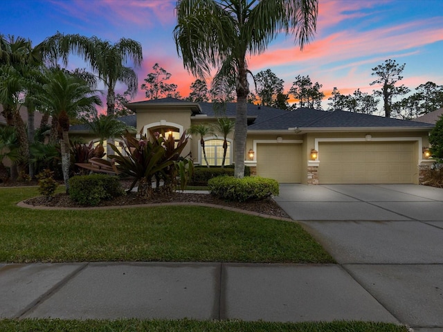 view of front of home featuring a garage and a lawn