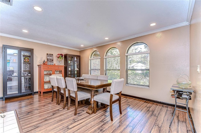 dining room with light hardwood / wood-style floors and ornamental molding