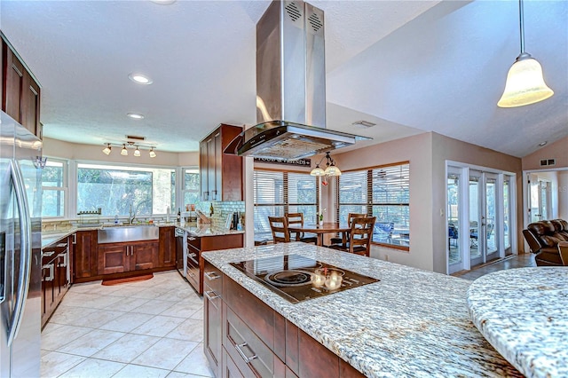 kitchen featuring light stone counters, sink, island exhaust hood, and stainless steel refrigerator with ice dispenser