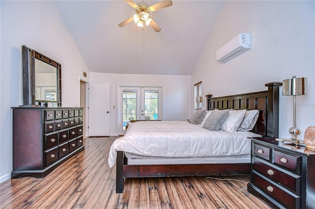 bedroom with a wall mounted air conditioner, french doors, ceiling fan, access to exterior, and wood-type flooring