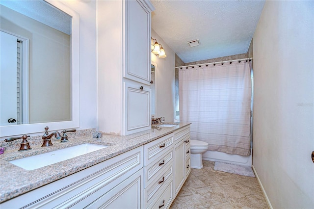 full bathroom with vanity, tile patterned flooring, toilet, shower / bath combo with shower curtain, and a textured ceiling