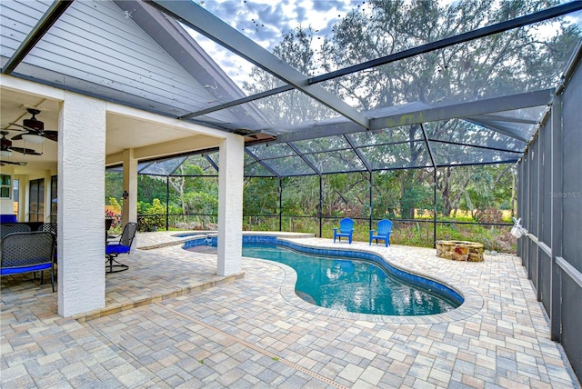 view of pool with glass enclosure, ceiling fan, and a patio area