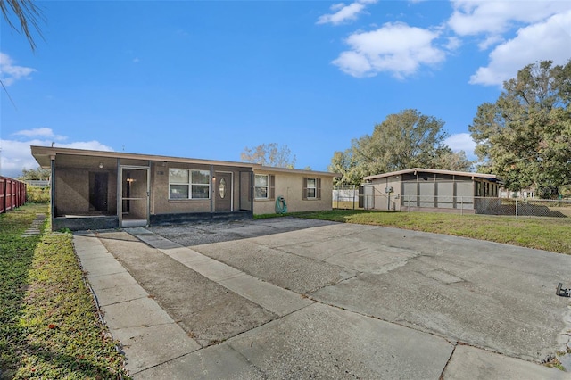 view of front of property featuring a sunroom and a front lawn