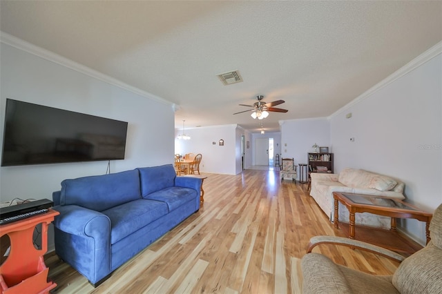 living room with hardwood / wood-style floors, ceiling fan with notable chandelier, a textured ceiling, and ornamental molding