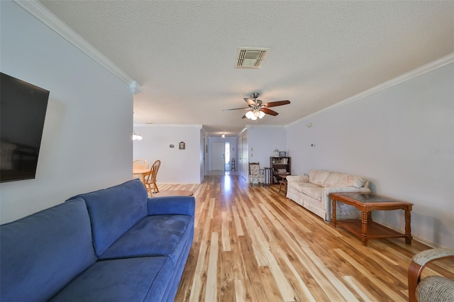 living room featuring a textured ceiling, ceiling fan, crown molding, and light hardwood / wood-style flooring