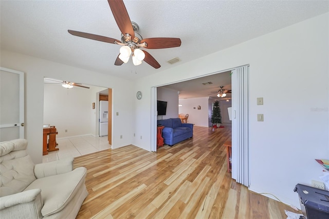 living room featuring light hardwood / wood-style floors and a textured ceiling