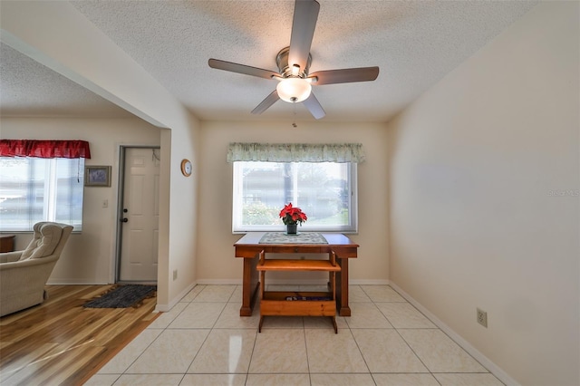 dining area with a wealth of natural light, ceiling fan, light tile patterned floors, and a textured ceiling