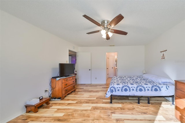 bedroom featuring a textured ceiling, light hardwood / wood-style floors, and ceiling fan