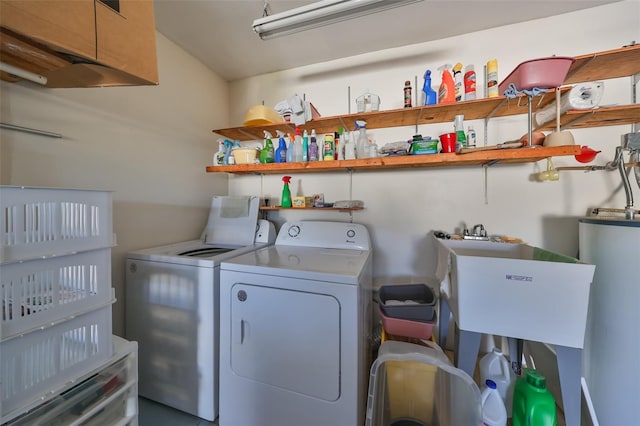 laundry area with washing machine and dryer, sink, and gas water heater