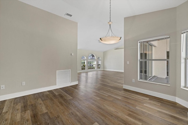 empty room with dark hardwood / wood-style flooring and high vaulted ceiling