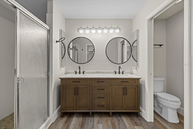 bathroom with vanity, hardwood / wood-style flooring, toilet, and an enclosed shower