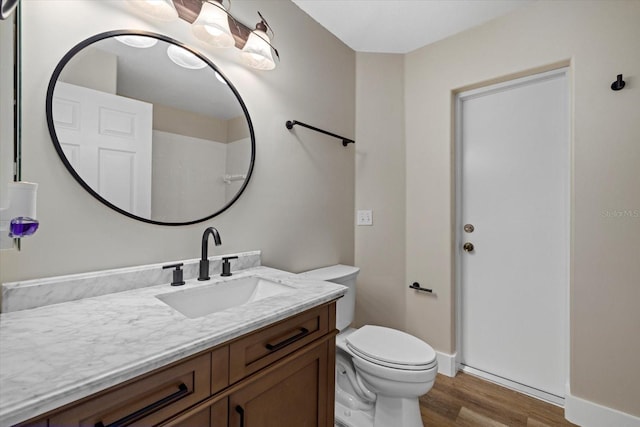 bathroom with hardwood / wood-style floors, vanity, and toilet