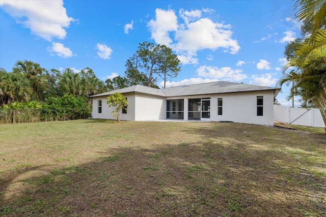 rear view of property with a lawn