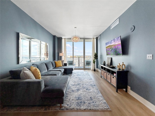 living room featuring light hardwood / wood-style flooring and a wall of windows