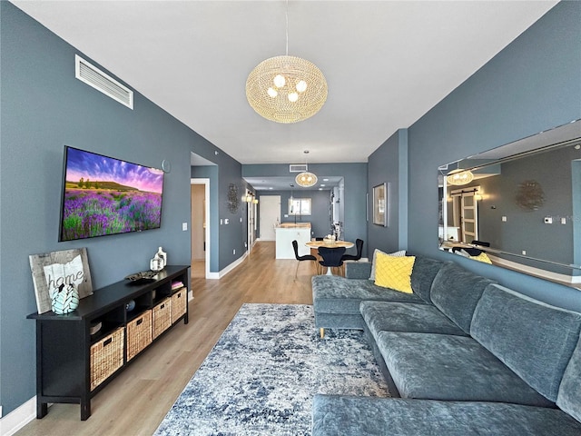 living room featuring light hardwood / wood-style flooring and a chandelier