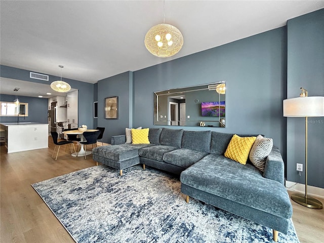 living room featuring hardwood / wood-style floors, a notable chandelier, and sink