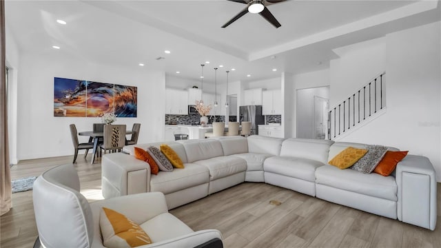 living room featuring ceiling fan and light hardwood / wood-style floors