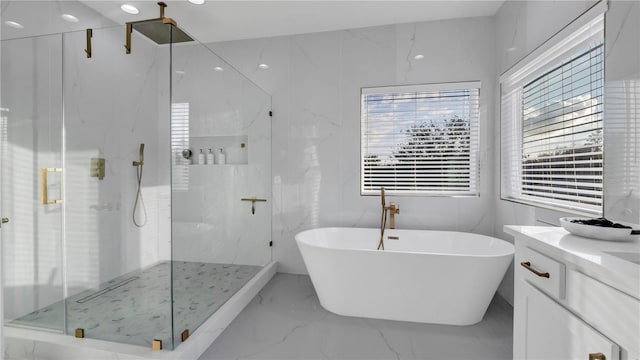 bathroom featuring shower with separate bathtub and vanity