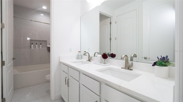 full bathroom with tiled shower / bath, vanity, and toilet