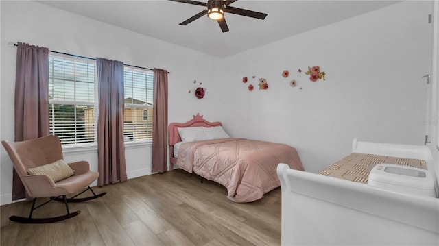 bedroom with ceiling fan, light wood-type flooring, and multiple windows