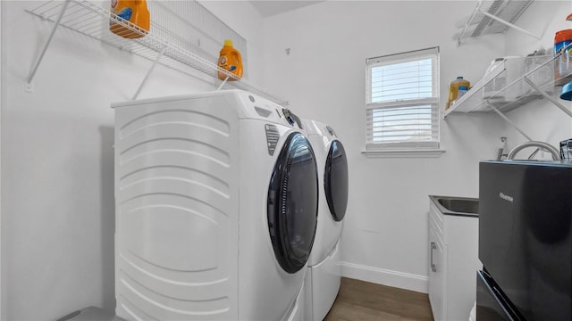 laundry room with washer and clothes dryer and dark hardwood / wood-style floors